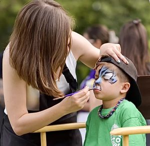 Professional face painter painting a child at a kids event in Toronto