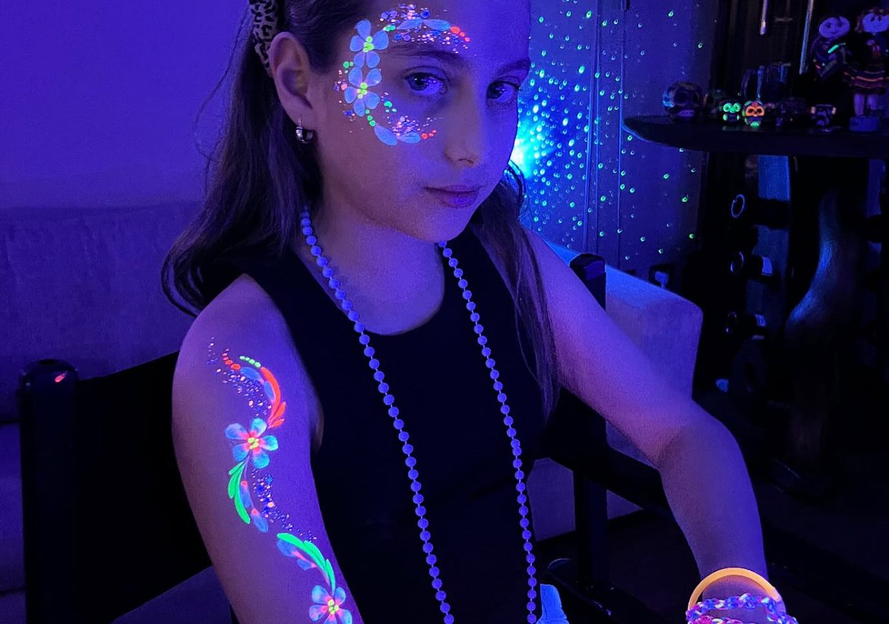 Colorful glitter tattoo designs glowing under UV light at a kids’ party in Toronto by Hello Event